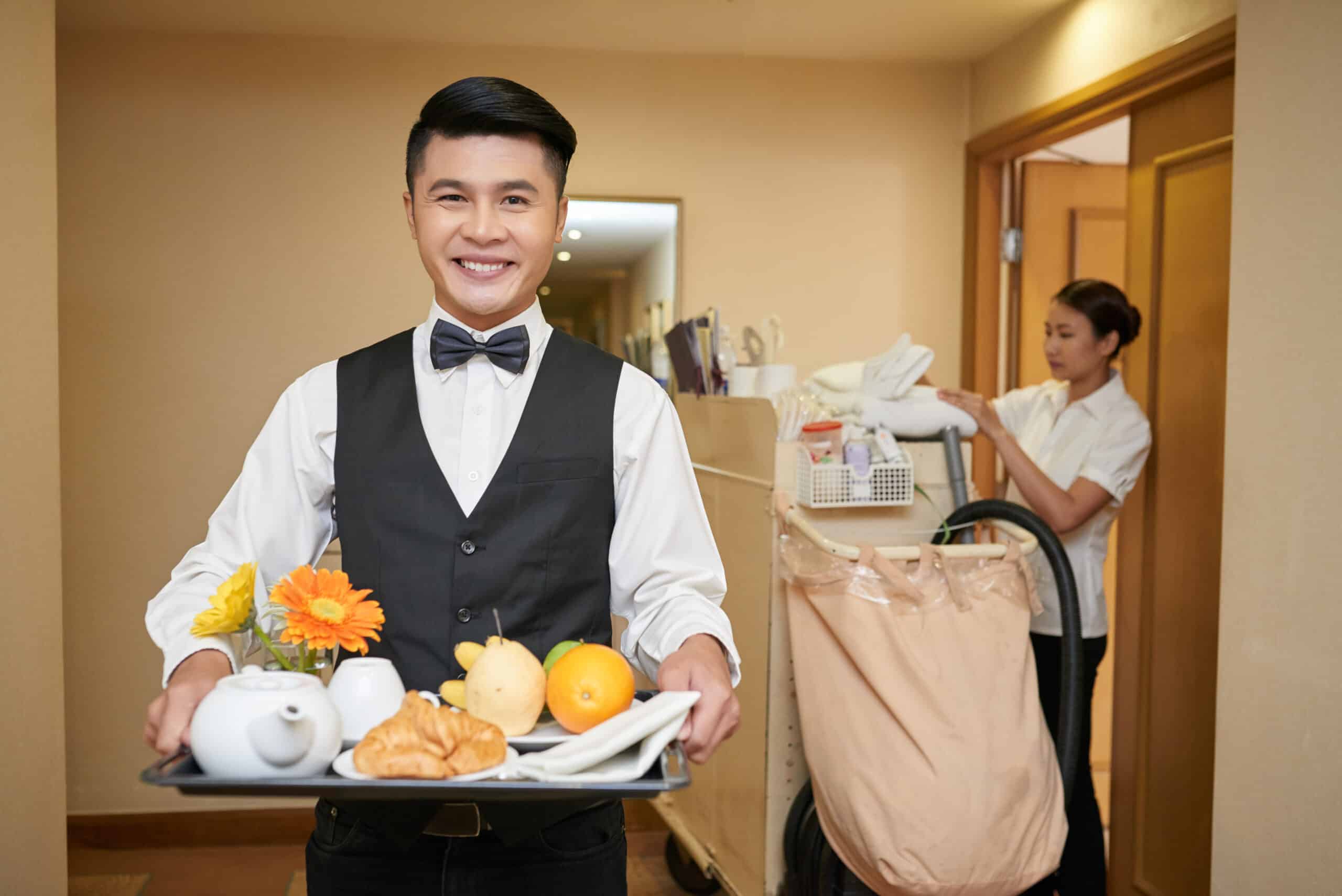 Portrait of smiling Vietnamese waiter and chambermaid in the background