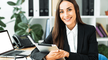 Gestionnaire de paie souriante dans un bureau, représentant l’accompagnement social et administratif proposé par PG-PS.