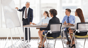Formateur professionnel animant une session de formation devant des salariés en entreprise, symbolisant la certification Qualiopi.