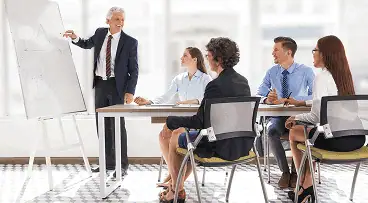 Formateur professionnel animant une session de formation devant des salariés en entreprise, symbolisant la certification Qualiopi.