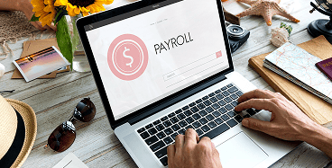 Formation en gestion de la paie avec un expert utilisant un logiciel de paie sur ordinateur portable.
