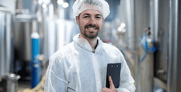 Professionnel de l’agroalimentaire en tenue de sécurité, illustrant la formation HACCP sur l’hygiène et la sécurité alimentaire.